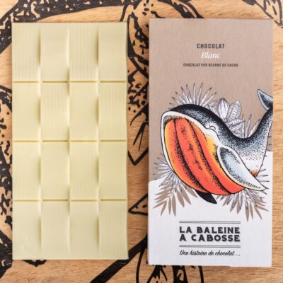 Tablette Chocolat blanc de La Baleine à Cabosse dans son emballage, posée à côté d'une tablette de chocolat blanc sans emballage