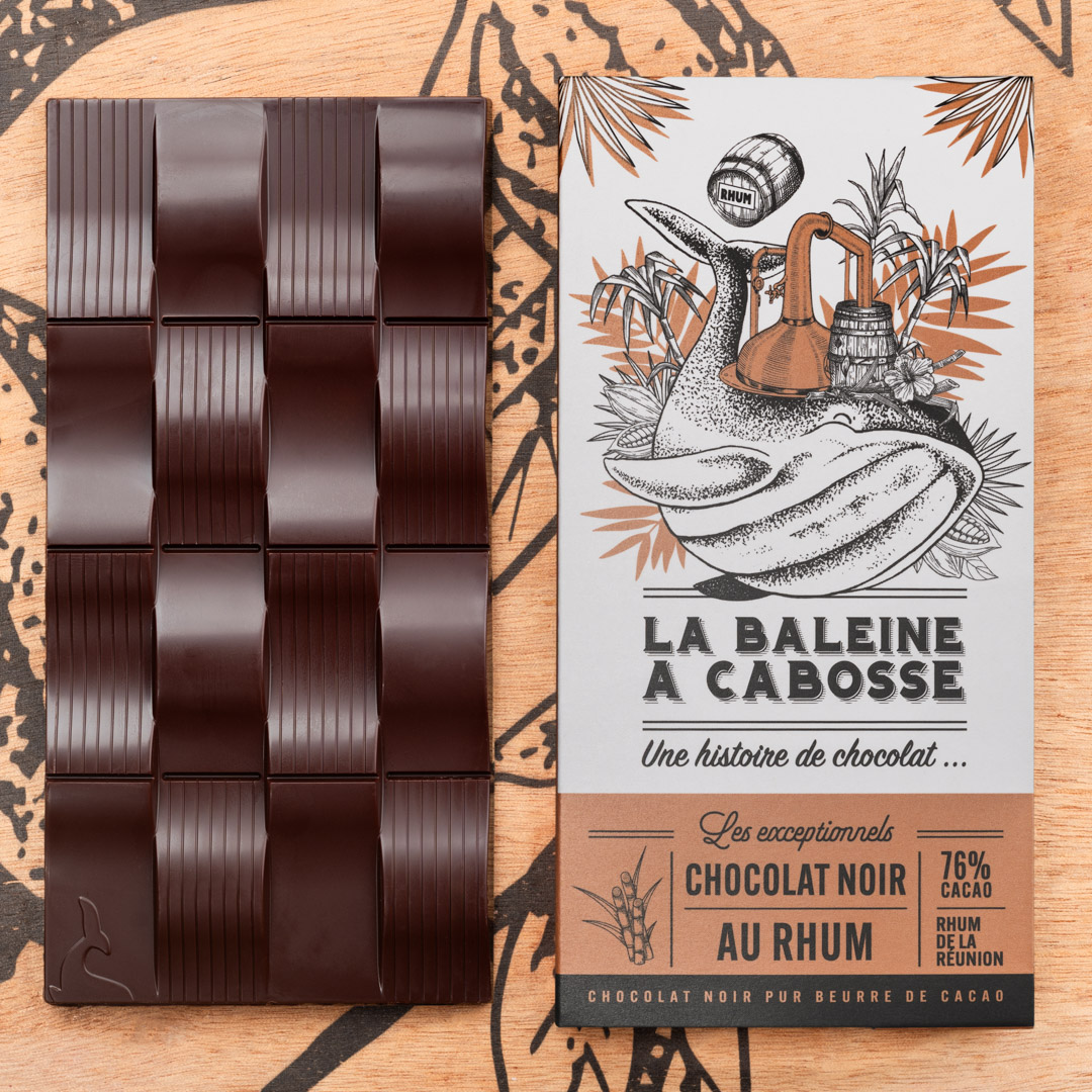 Tablette chocolat au Rhum de la Réunion. Edition limitée 1 tablette de chocolat noir au rhum de la Réunion dans son emballage, posée à côté de la tablette de chocolat noir sans emballage