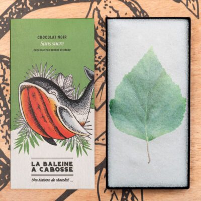 tablette de chocolat noir sans sucre de La Baleine à Cabosse dans son emballage, posée à côté d’un moule en forme de tablette avec une feuille de bouleau